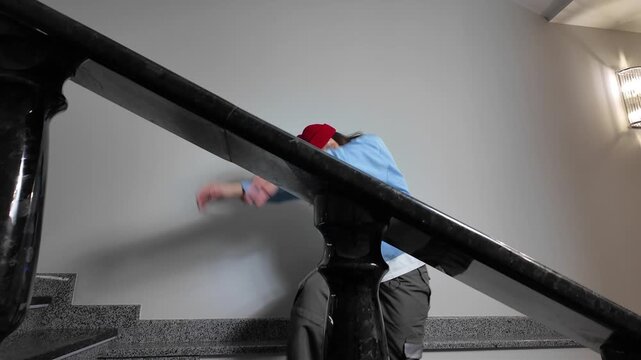 Young Woman in Red Beanie Freestyle Dancing Hip Hop on a Staircase in a Modern Building Lobby