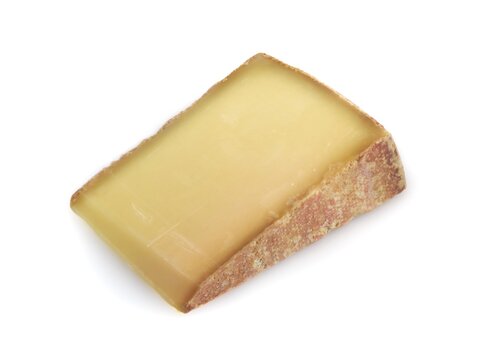 Piece of french beaufort  cheese on white background	.