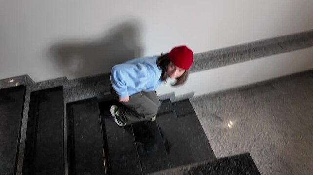Young Woman in Red Beanie Freestyle Dancing Hip Hop on a Staircase in a Modern Building Lobby