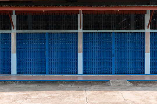 Minimal blue building facade with columns and concrete floor, geometric architecture background