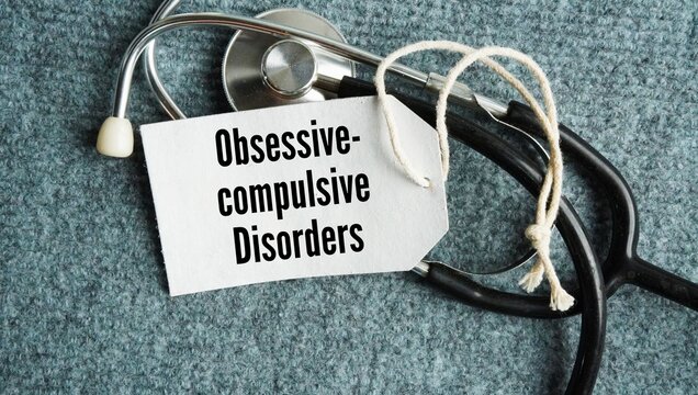 A stethoscope and a paper tag with the words obsessive-compulsive disorders. mental health condition that causes unwanted, recurring thoughts and the urge to repeat specific behaviors.