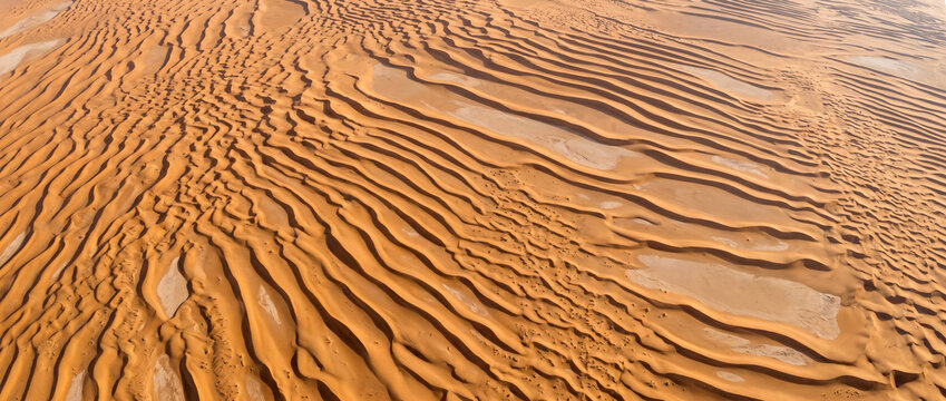 Flowing Rub Al Khali dune waves across an arid landscape