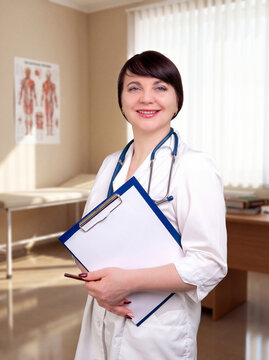 Smiling female doctor with stethoscope and notepad in bright clinic office