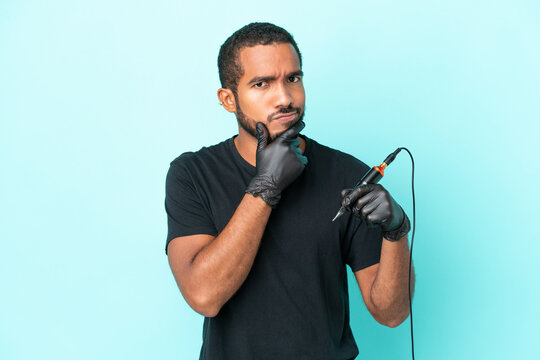 Tattoo artist Ecuadorian man isolated on blue background thinking