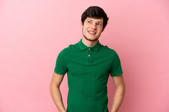 Young Russian man isolated on pink background thinking an idea while looking up
