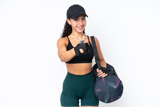 Young sport woman with sport bag isolated on white background with thumbs up because something good has happened