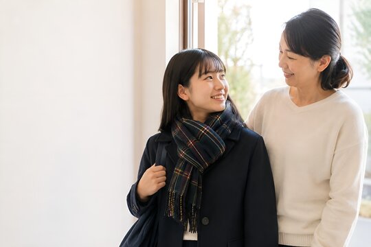 冬の朝に塾や自習へ出かける高校生の娘を見送る日本人の母親 受験期の親子の風景（AI生成）