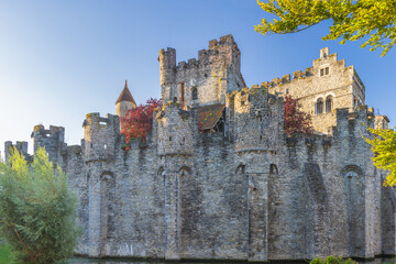 Gravensteen, a medieval castle in the city of Ghent in Belgium, Europe. Historic Stone Castle with Turrets and Moat Under Clear Sky, Medieval Architecture Illuminated by Sunlight © Viliam