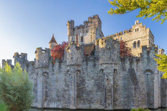 Gravensteen, a medieval castle in the city of Ghent in Belgium, Europe. Historic Stone Castle with Turrets and Moat Under Clear Sky, Medieval Architecture Illuminated by Sunlight