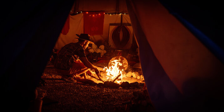 Caring for a Sacred Ritual Fire Inside a Ceremonial Teepee at Night.