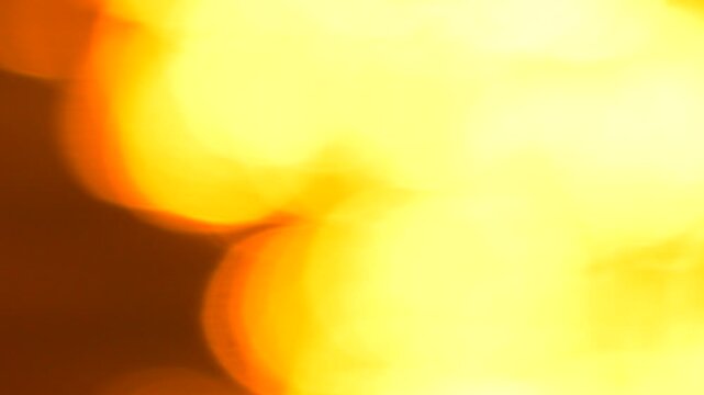 Golden light orbs glow across a dark surface, creating rhythmic warmth in this motion background. Macro bokeh, handheld shaky camera movement.