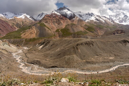 Achik-Tash river bend below colorful peaks, route to Lenin peak in cloudy weather in summer