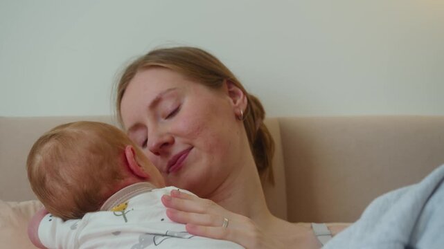Mother talks affectionately to baby while continuing gentle strokes. Voice and touch work together, giving infant familiar rhythm and turning ordinary interaction into responsive communication.
