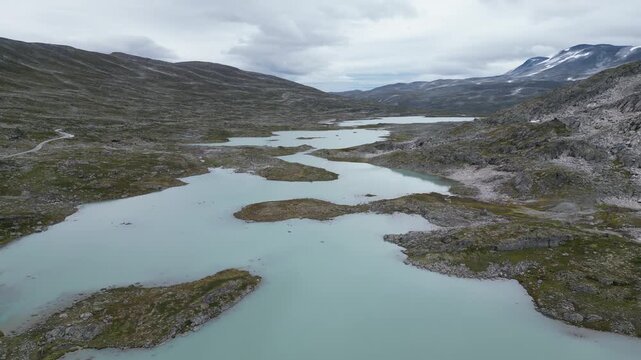 Slow aerial forward glide over serene glacial mountain lake, Jostedalsbreen region, Norway