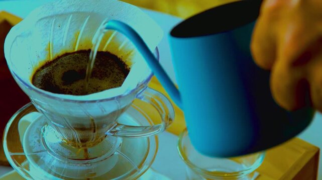 Pouring hot water over coffee grounds in a pour-over brewer