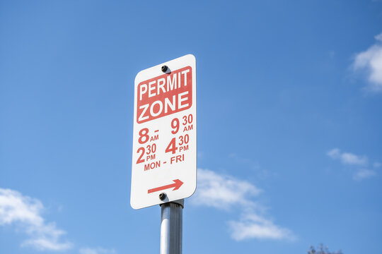 Australian permit zone parking sign&nbsp;against a blue sky, restricting street parking during school pick-up and drop-off hours on weekdays in Melbourne Victoria, Australia.
