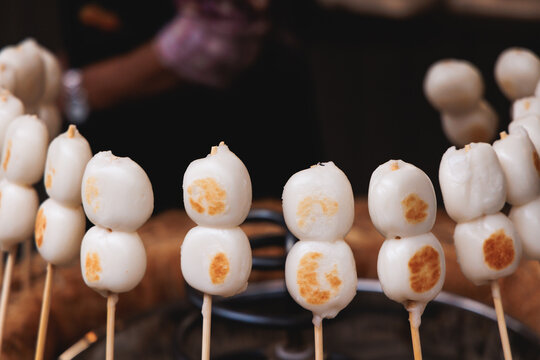 Dango on skewer, Mitarashi dango, traditional Japanese street food, grilled rice cake balls dumplings on wooden sticks, street food festival, Tokyo, Japan, market with local vendor stalls cooking
