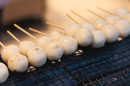 Dango on skewer, Mitarashi dango, traditional Japanese street food, grilled rice cake balls dumplings on wooden sticks, street food festival, Tokyo, Japan, market with local vendor stalls cooking