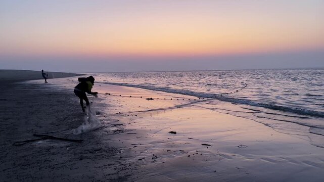 Cox's Bazar, Bangladesh &ndash; February 5, 2023: Fishermen Pull Fishing Nets from Sea at Sunrise