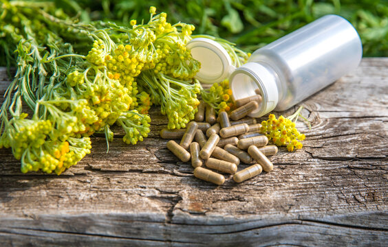 Helichrysum extract in a bottle and capsules. Selective focus.