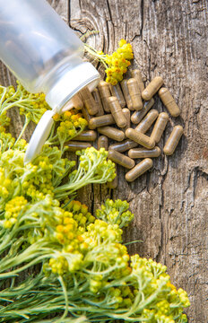 Helichrysum extract in a bottle and capsules. Selective focus.