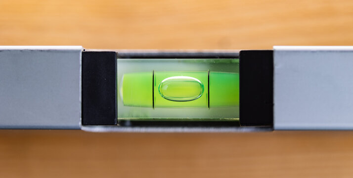 A close-up view from above of a spirit level that is in balance. Accuracy, scale, handyman work tool, craftsman, construction industry, or carpentry.