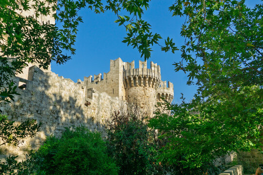 Medieval castle towers of the Palace of the Grand Master in Rhodes framed by green leaves
