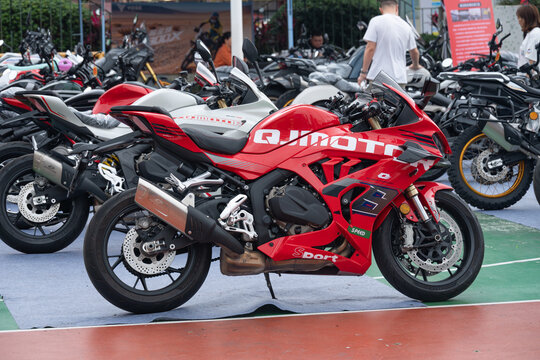 ZhongShan GuangDong China-April 11 2026: QJMOTOR QJ800 G S-J red sport motorcycle parked on exhibition ground among other motorbikes.