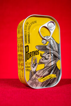 ZhongShan GuangDong China-October 18 2025: Porthos sardines in olive oil tin can set against bright red background.