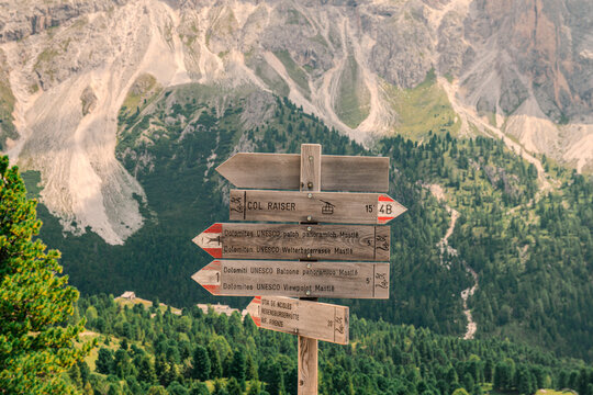 Hiking trail signs at Seceda in the Dolomites with dramatic mountain landscape, South Tyrol, Italy
