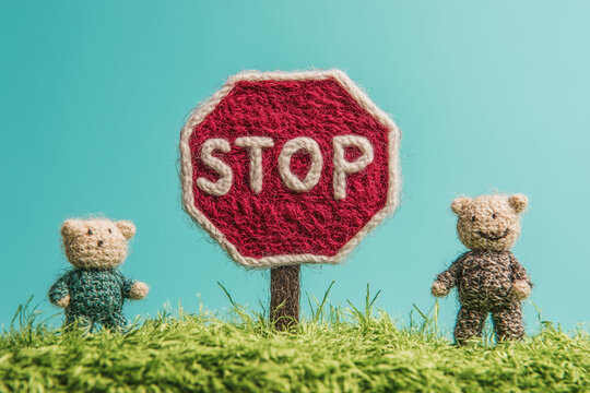 Red knitted stop sign with teddy bears on a light blue background.