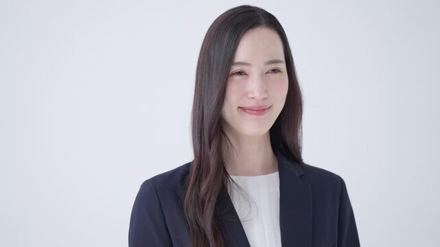 胸に手を当てるスーツのビジネスウーマン