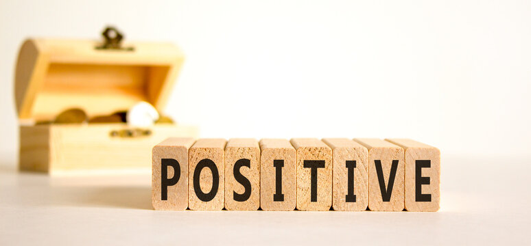 Positive word symbol. Concept word Positive on beautiful wooden blocks. Beautiful white background. Beautiful wooden chest with coins. Business support help positive word concept. Copy space.