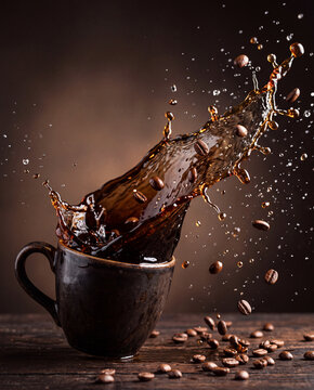 Coffee splash from a cup, rich brown liquid, coffee beans, dynamic action