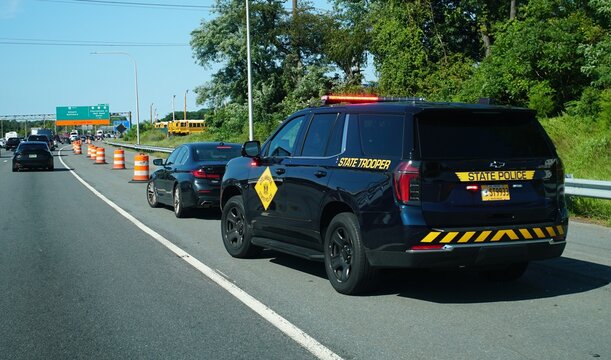 Newark, Delaware, U.S.A - Aug 29, 2026 - Delaware State Trooper vehicle pulled over a driver beside highway construction barrels with slow-moving vehicles on I-95 South.