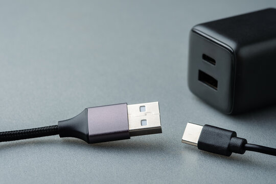 USB-A and USB-C cable connectors with power adapter representing compatibility, different connection standards, device selection and choosing the right charging interface