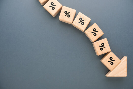 Percentage symbols following a downward arrow representing falling interest rates, rate cuts, declining returns and changing financial conditions