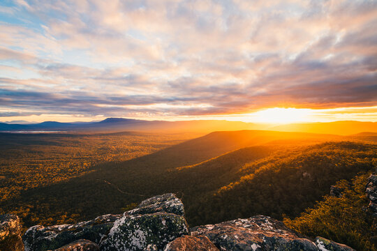 Mountain vista landscape in Grampians National Park, Victoria, Australia, during a bright, dramatic sunset with stormy clouds.