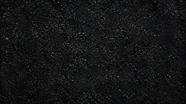High-resolution top view of dark asphalt texture, capturing detailed rough bitumen surface, aggregate stone pattern, road pavement material, and dark urban tarmac background.
