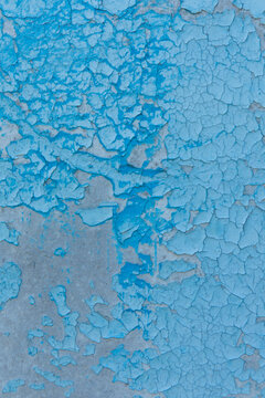 Cracked paint texture showing a blue pattern on a surface in a worn-down environment