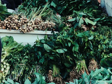 Fresh lemongrass stalks and green leafy vegetables display at Indonesian market