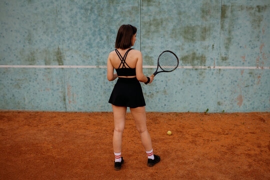 Young woman playing tennis on clay court