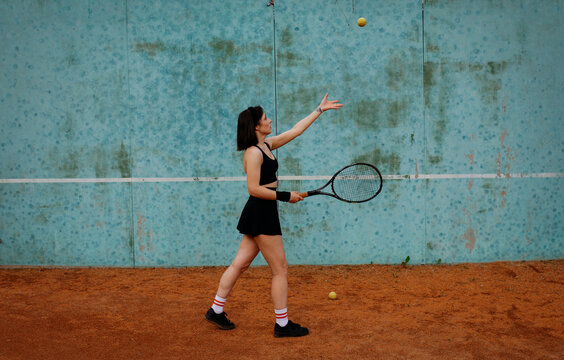Young woman playing tennis on clay court