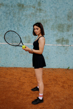 Young woman playing tennis on clay court