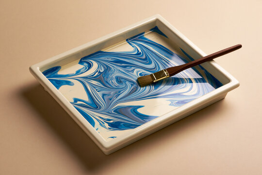 Traditional Turkish ebru marbling tray with swirling color pattern craft