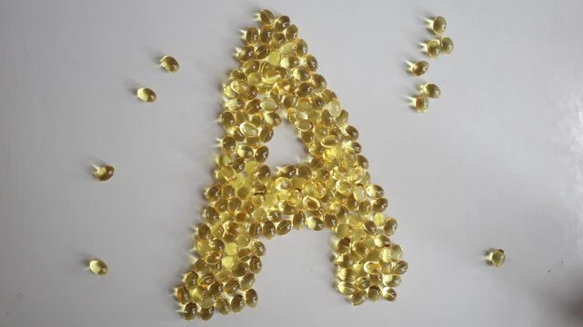 Vitamin A softgel capsules form a large letter A on white background highlighting daily supplement use essential nutrition wellness vision skin health and balanced living
