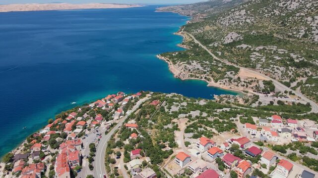 Aerial view of a coastal village and road beside the blue sea