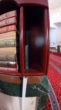 Pan from a wooden Quran bookshelf to the spacious red-carpeted prayer hall of Ijabah Mosque.