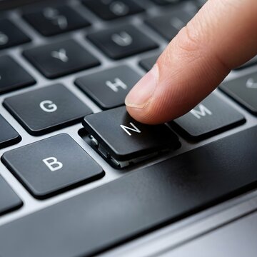 Close-up of a human finger pressing a broken N key on a black laptop keyboard, showing the mechanical structure beneath the partially detached keycap during a technical repair.