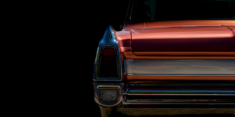 Classic vintage car tail fin and chrome bumper detail on black background with copy space © istvan